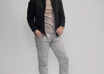man wearing black bomber jacket with gray jeans and sneakers