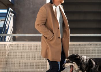 scandinavian men's style outfit inspiration with camel topcoat, sweater, watch cap, and white sneakers