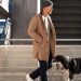 scandinavian men's style outfit inspiration with camel topcoat, sweater, watch cap, and white sneakers