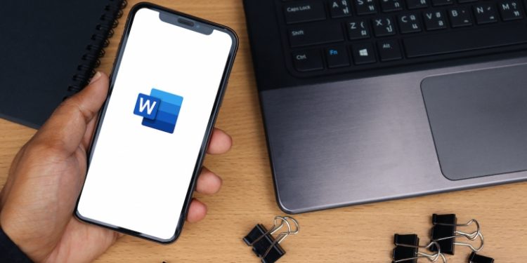 Microsoft Word app logo on smartphone screen, desk background - Chiang Mai, Thailand October 10, 2021