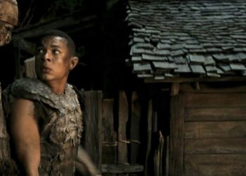 Arondir the elf looks back in surprise when he bumps into a giant orc in Rings of Power.